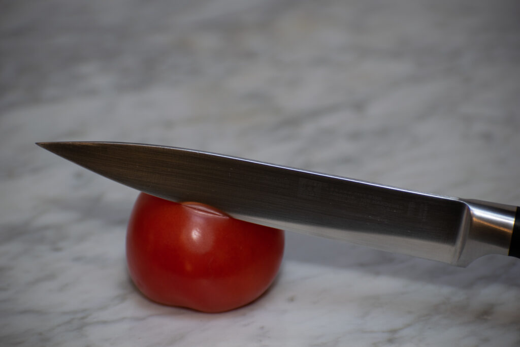 stumpfes Messer auf Tomate